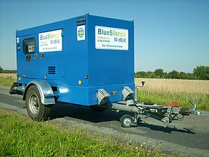 Blauer Stromgenerator auf einem Anhänger an einer Landstraße